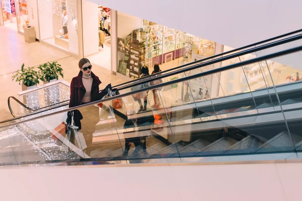 lady with shopping bags on a mall escalator