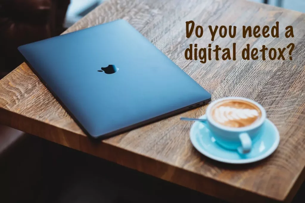 Quote: Do you need a digital detox? Image: Macbook on table with cup of coffee.