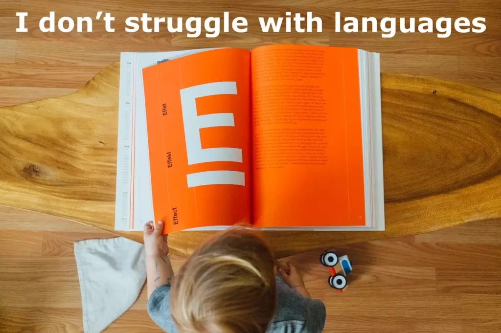 Image of toddler reading a large book. Quote: I don't struggle with languages.