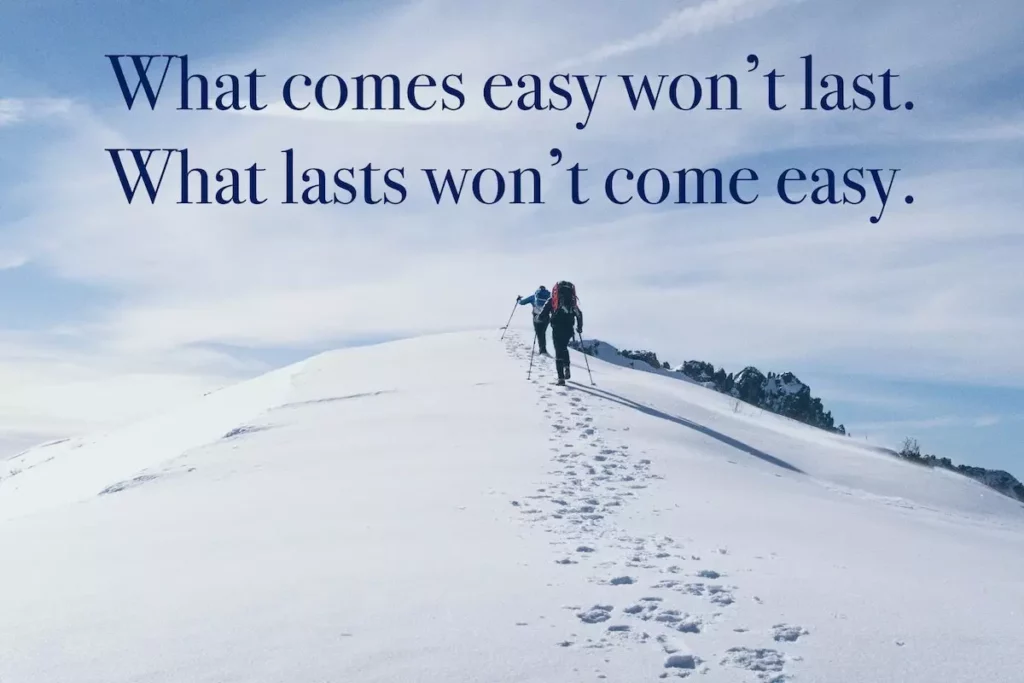 Image of two climbers tracking up a snowy mountain with the quote: what comes easy won't last. what lasts won't come easy.