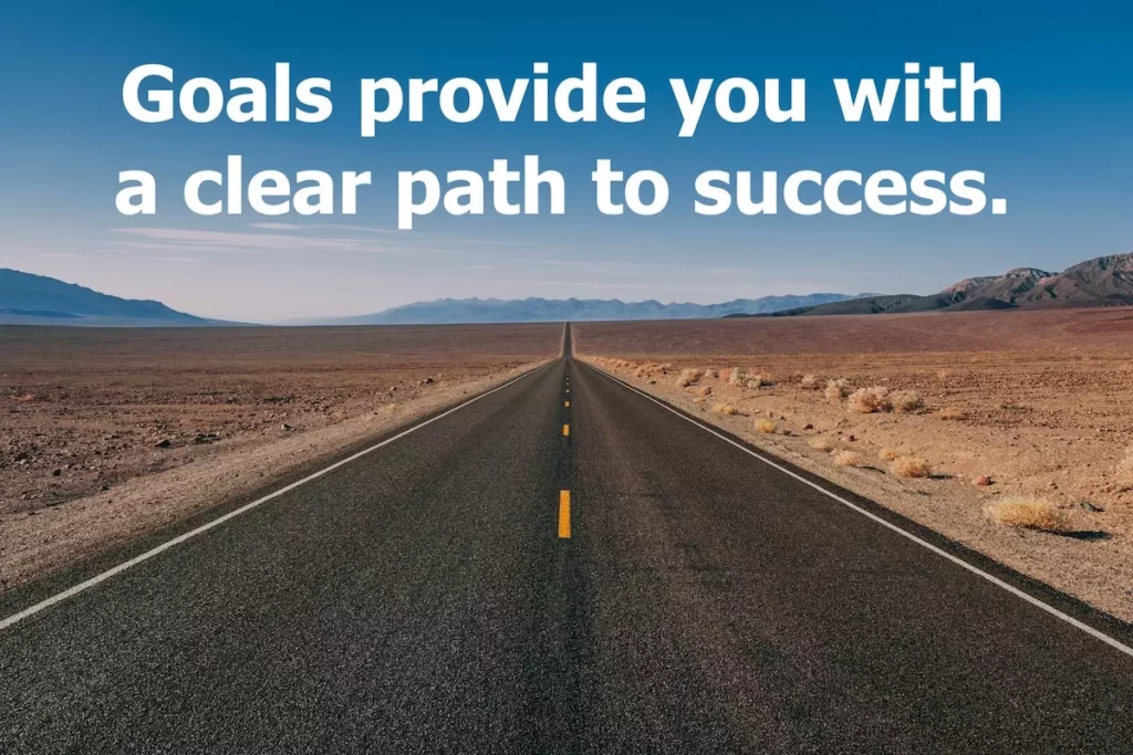 Image of tarmac road though the desert into the horizon with quote: Goals provide you with a clear path to success.