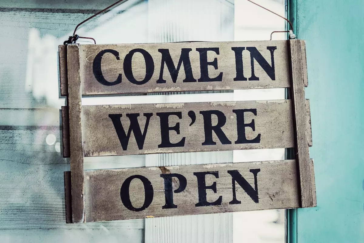 Image of a business sign saying, 'Come in, we're open'.