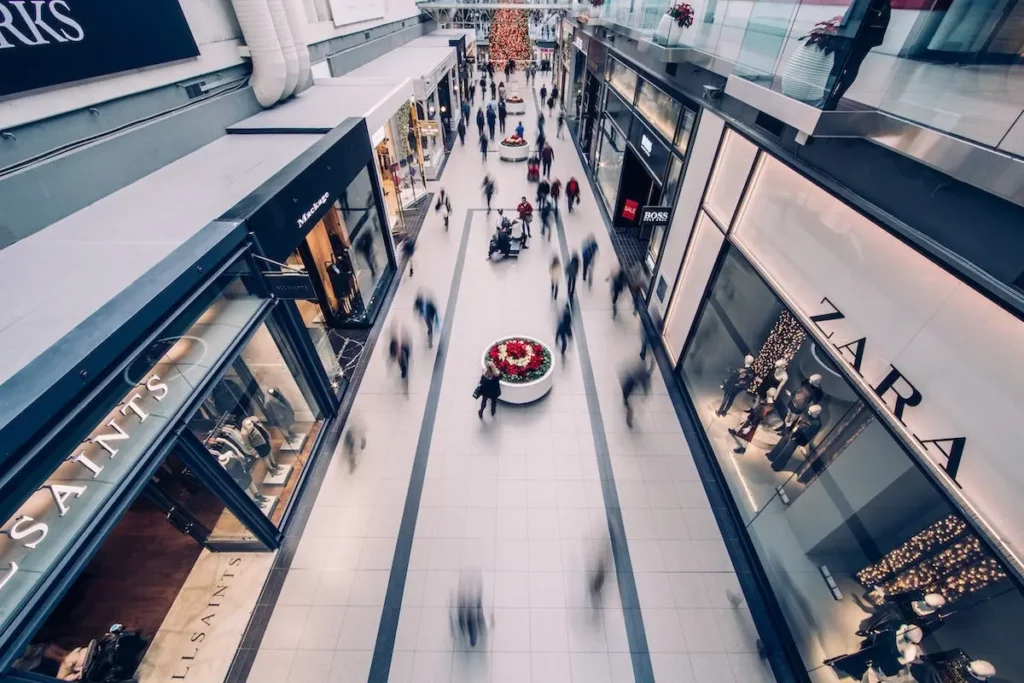 Image of a shopping mall with shoppers walking throughout the mall.