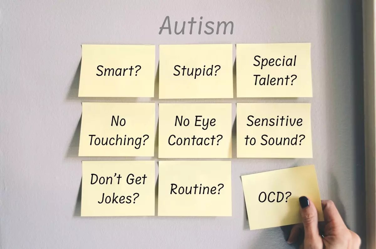 Image of post-its on a wall; listing common traits of autism