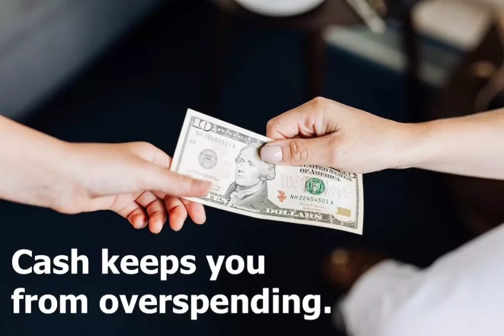 Image of person handing another person a 10 dollar bill with the text overlay: Cash keeps you from overspending.