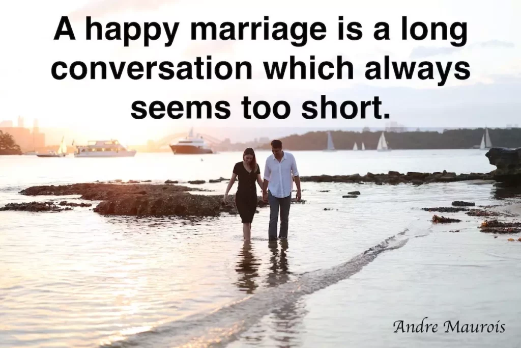 Image of a couple walking along a beach with the text overlay: A happy marriage is a long conversation which always seems too short - Andre Maurois.