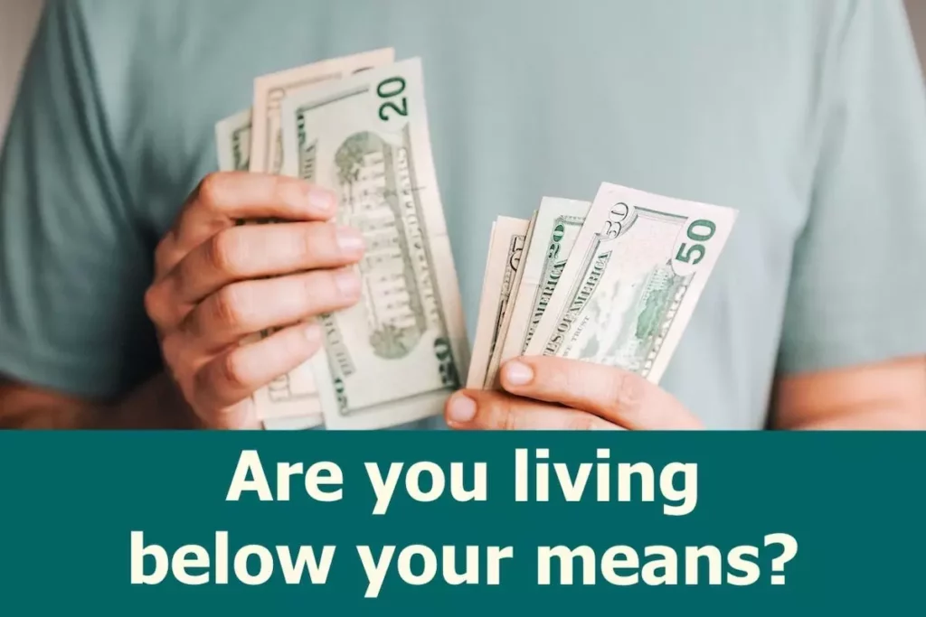 Image of a person with many dollar bills in his hands with the text overlay: Are you living below your means?