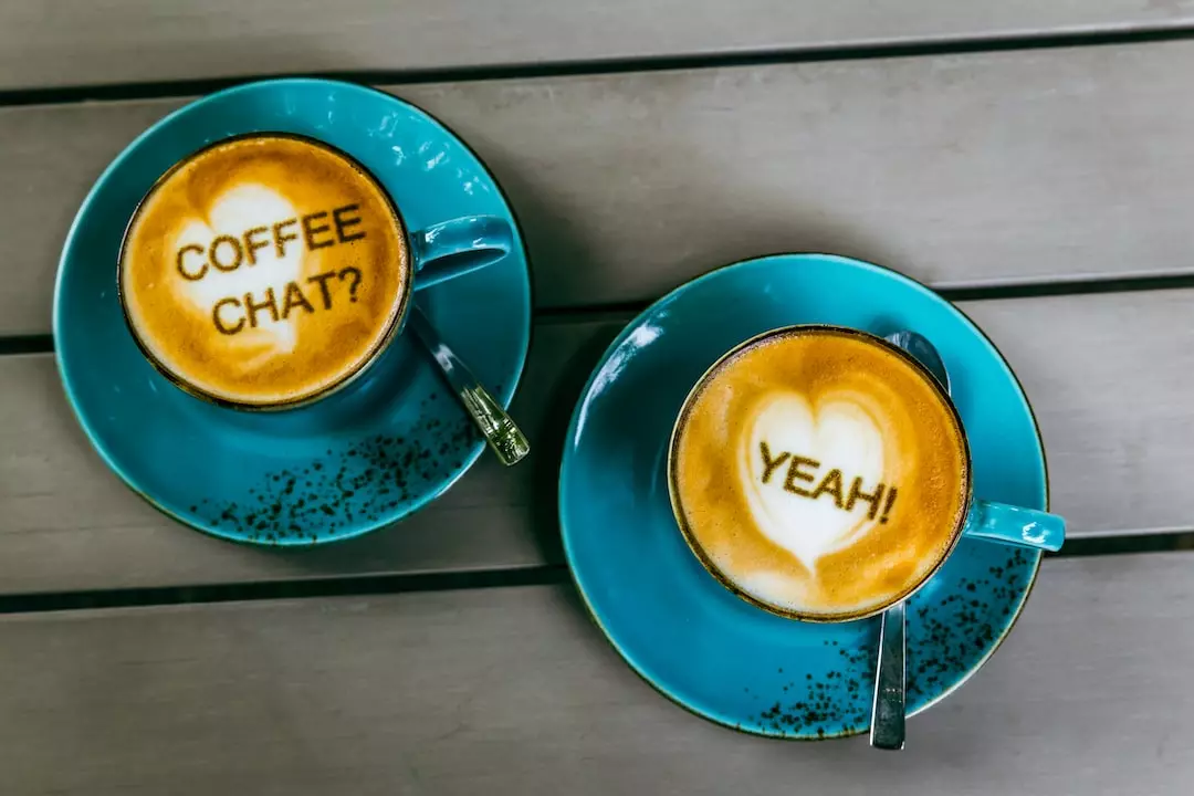 Image of two coffee cups with the text overlay: Coffee chat? Yeah!