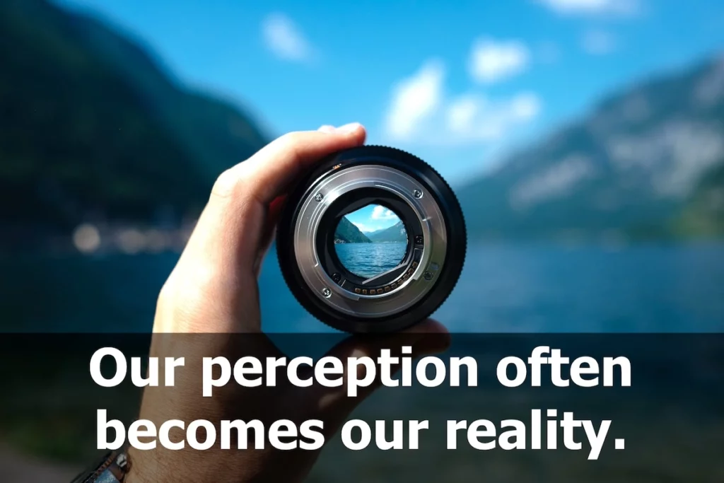 Image of someone looking through a camera lens with the text overlay: Our perception often becomes our reality.