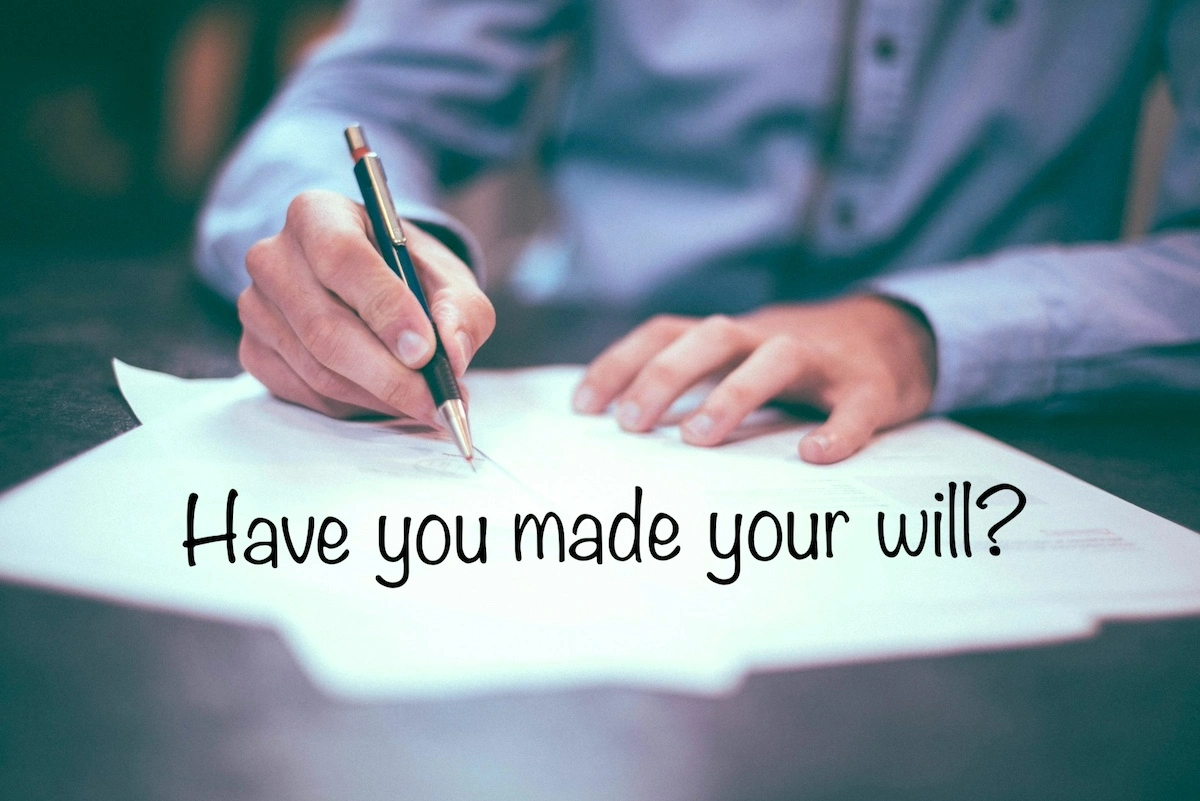 Image of person signing a document with the text overlay: Have you made your will?